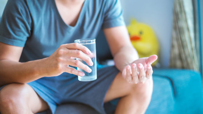 Man sitting and hold glass of water.